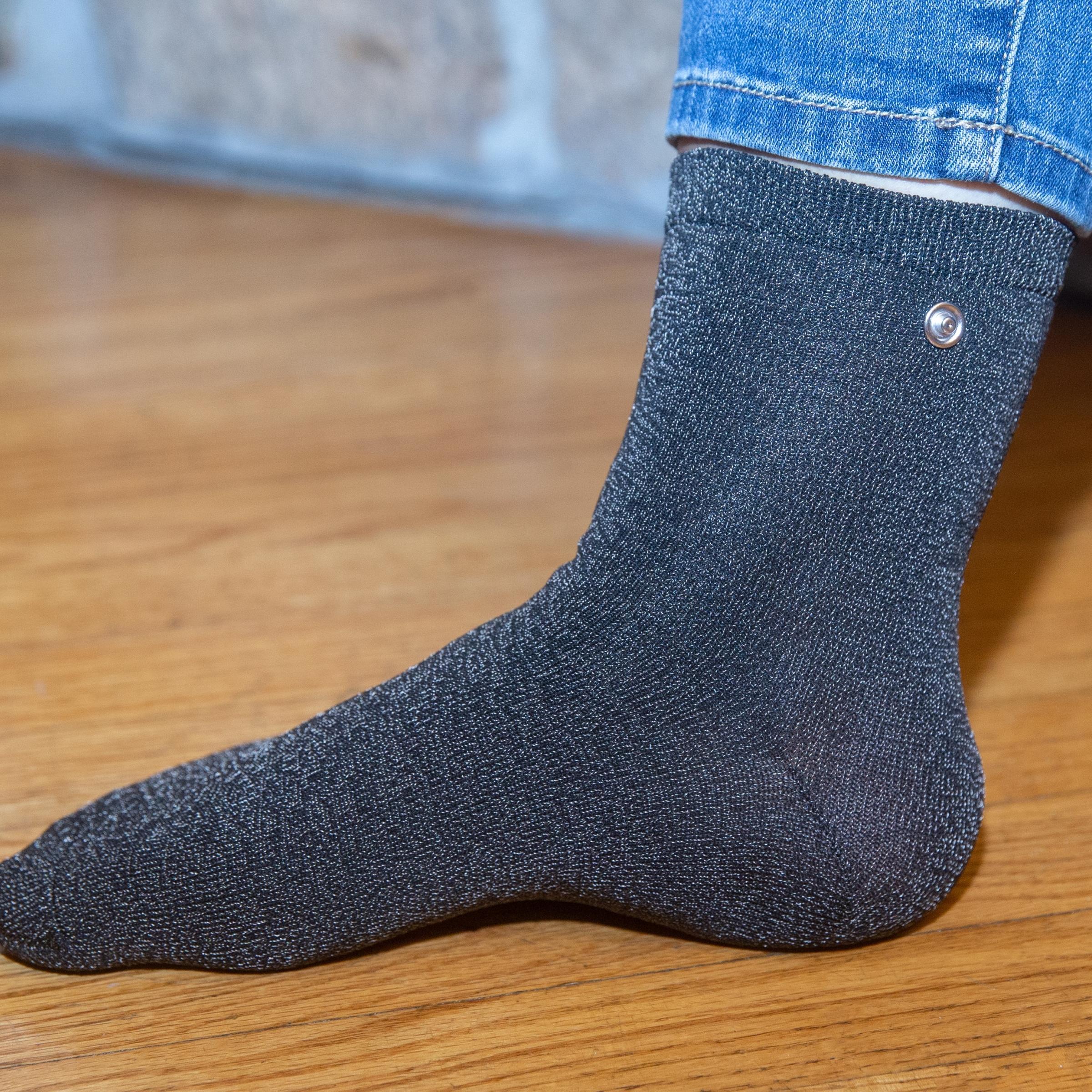 Wearing a grounded Earthing Sock for grounding indoors.  (6640015900785)